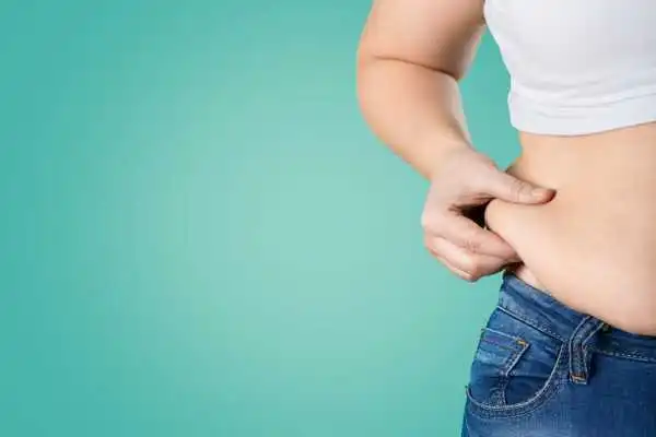Image of woman pinching her love handles to show weight gain Bagshot